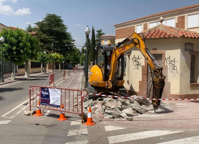 Excavadora trabajando en la acera pública de la calle